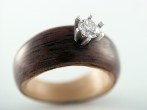 Early 2007 wooden ring with a dark wood exterior, pale inner liner, and raised setting.