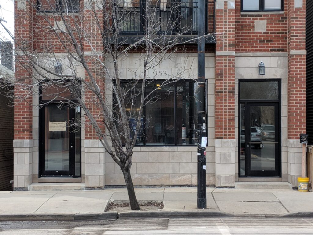 Street view of the Simply Wood Rings and Gustav Reyes studio storefront at 953, with both names visible on the door signage.