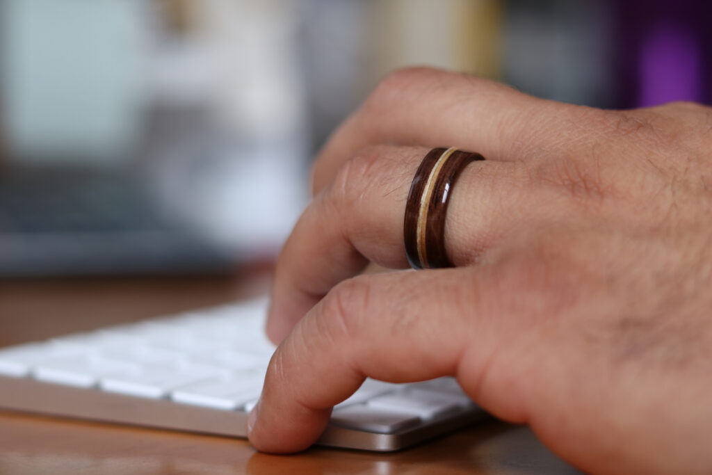 A finished Simply Wood Rings wood band worn on the hand.