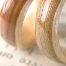 Three early laminated wooden rings photographed in 2007 resting on a printed page.